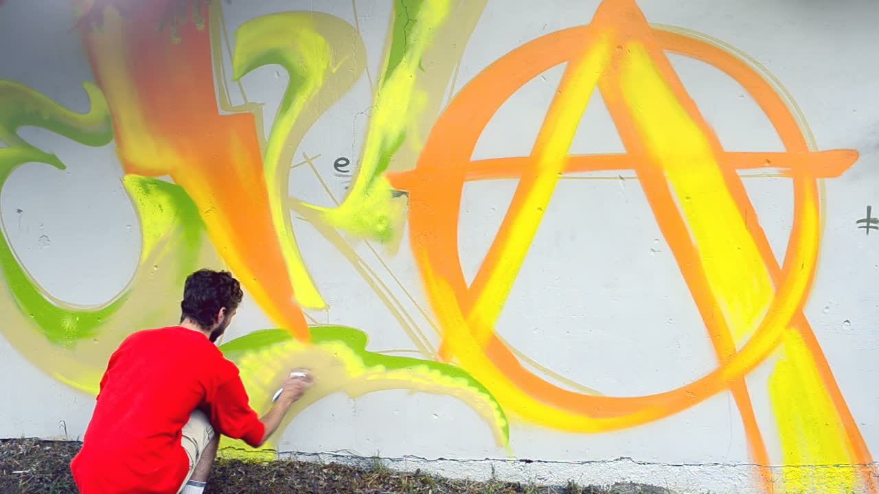 L'artista disegna graffiti su una recinzione. Graffiti su una recinzione.