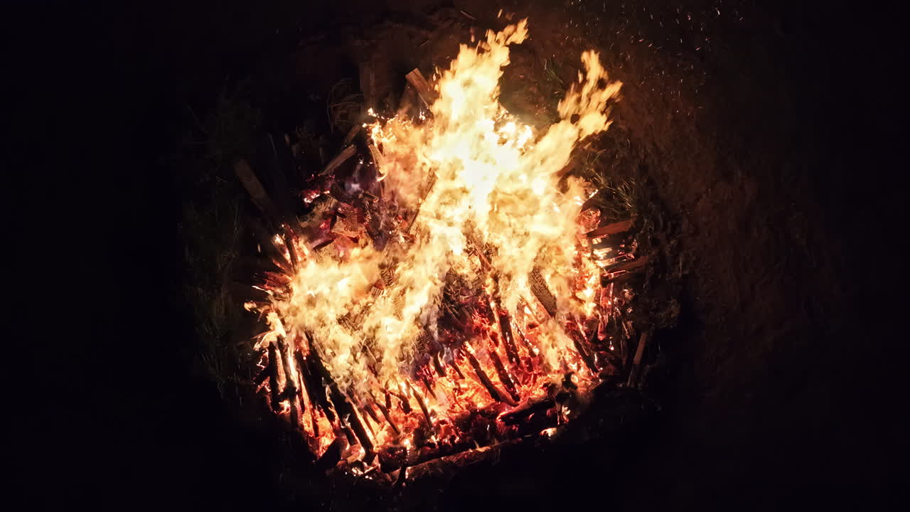 Massive bonfire with hot flame, aerial slow motion view