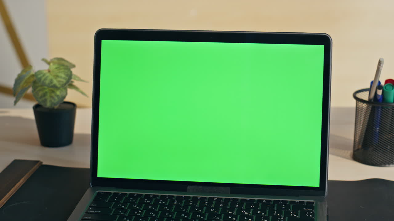 Empty chroma key laptop display on workplace closeup. Green screen computer