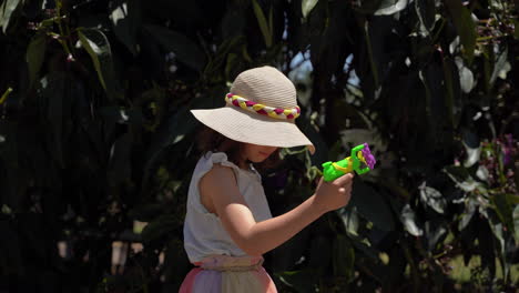 portrait young girl playing with bubble gun smiling sunny day