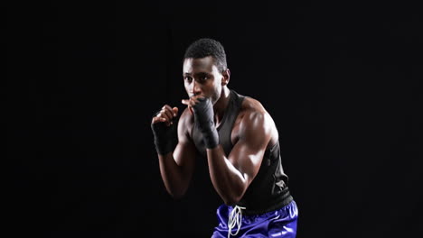 african american boxer poised in a fighting stance on a black background