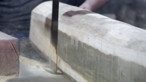 woodworking: hand sawing a wooden beam