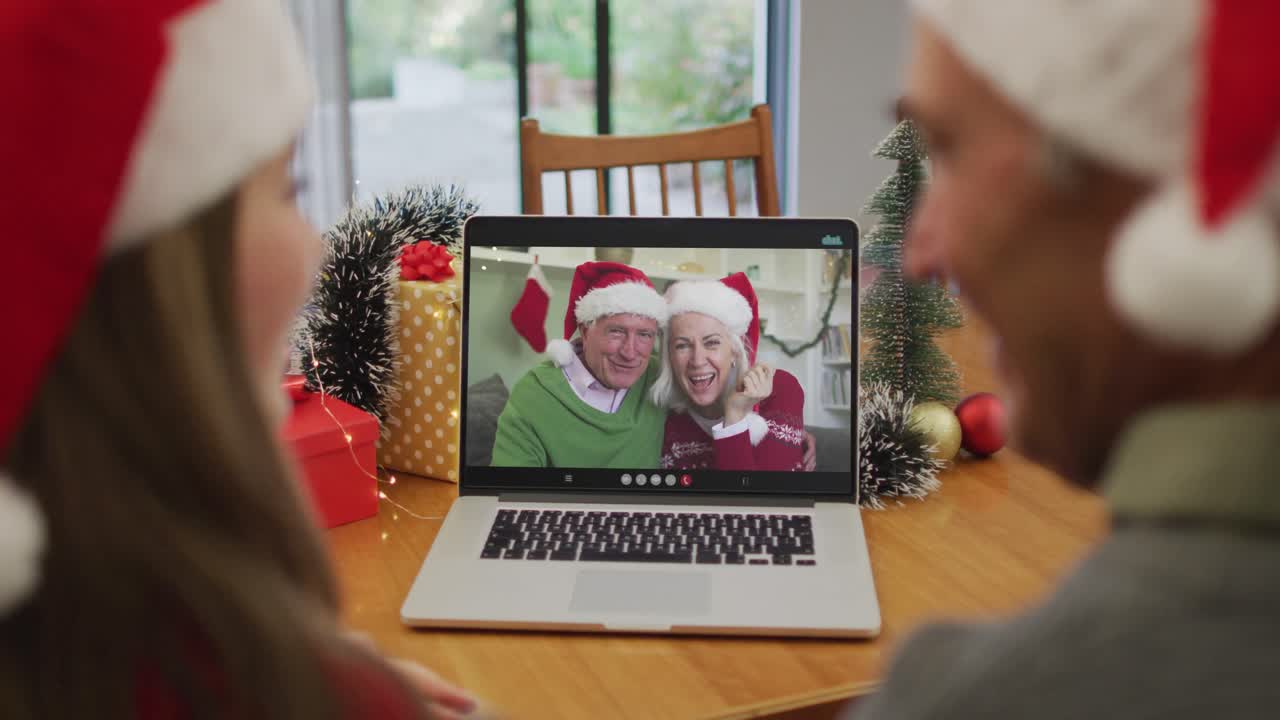 feliz pareja de ancianos caucásicos en videollamada con amigos mayores en tiempo de navidad