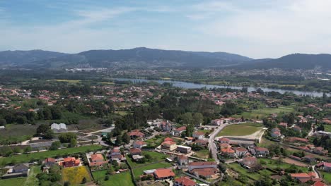 aerial flying into village, revealing detailed landscape and approaching igreja de serreleis in viana do castelo, portugal