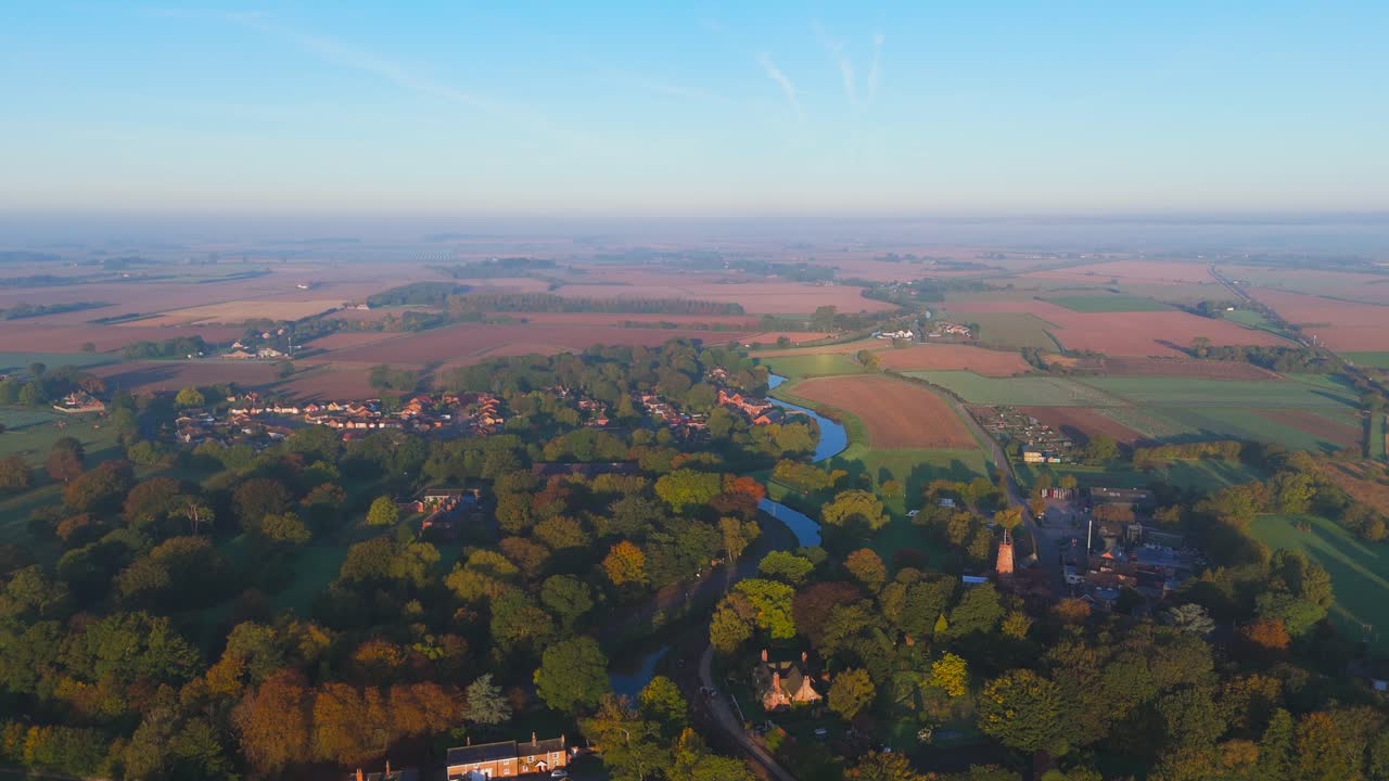 Misty autumn morning with farmlands and countryside views, wide vistas across open fields with crops set for overwintering. cold days in a rural village setting
