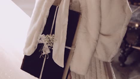 close up of a bride holding a black wedding book wrapped in lace and flowers