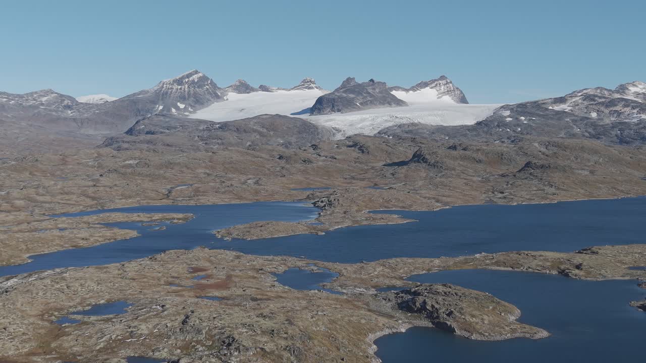Areal footage of snow covered mountain peaks in Jotunheim National Park, Norway