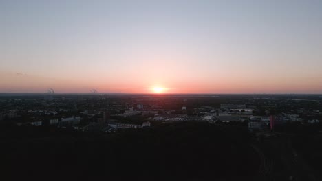 Descending-camera-flight-of-the-panorama-sunset-seen-from-Cologne,-Germany-in-June-2022-with-a-red-blue-sky-without-clouds