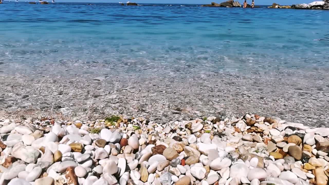 바다의 파도와 함께 은 날에 색의 자갈이 있는 해변