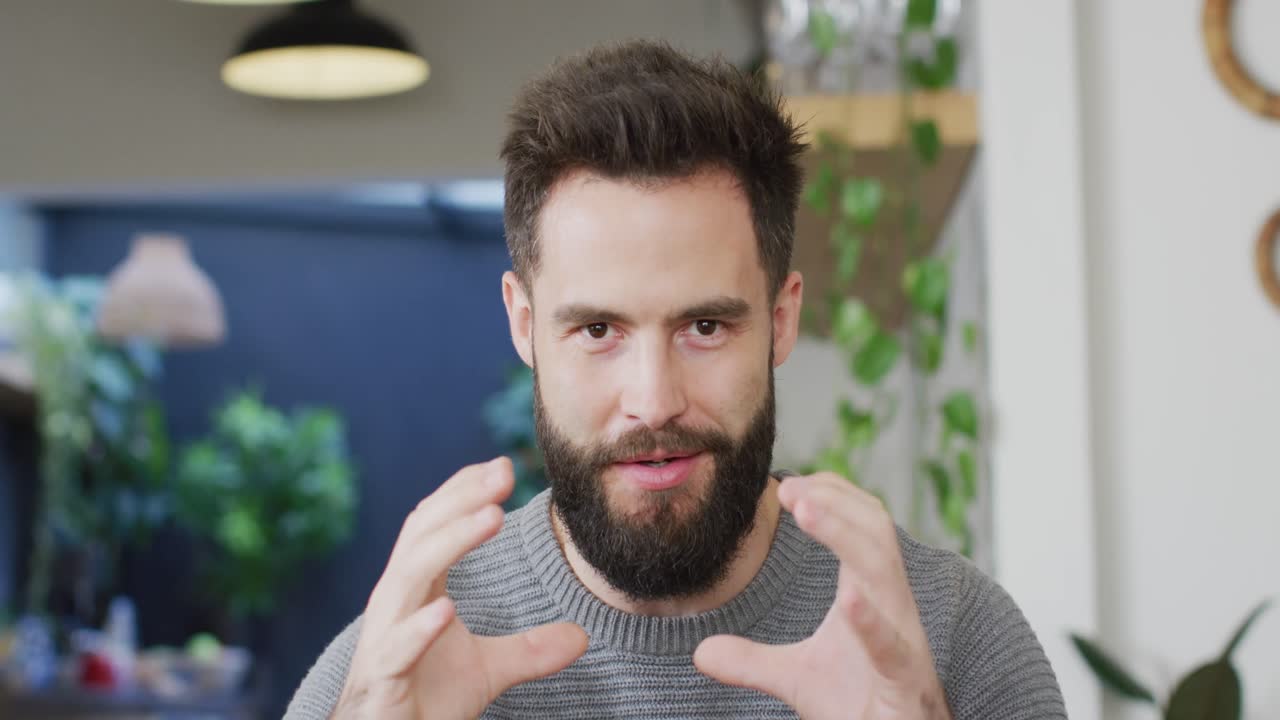 video de un hombre caucásico feliz y barbudo hablando y gesticulando, haciendo una videollamada en casa, copia el espacio