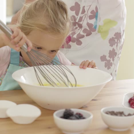 little girl baking with her mother