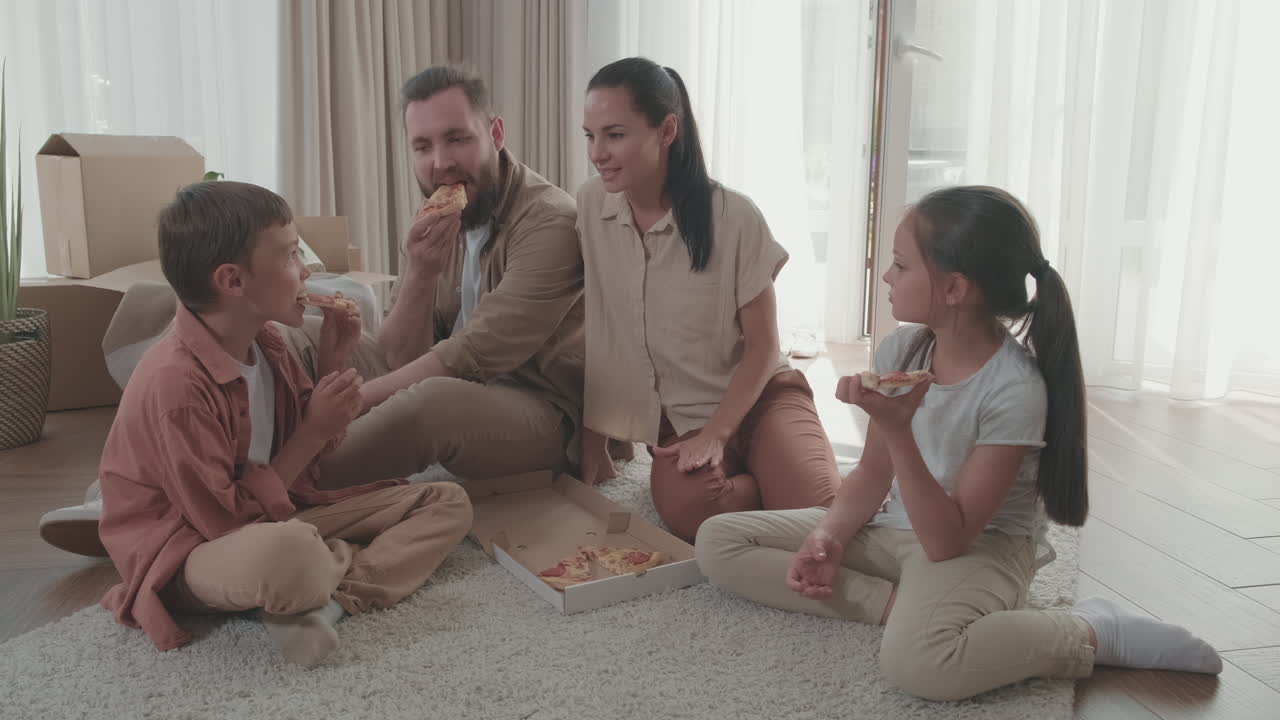 새로운 집에서 피자를 먹는 행복한 가족