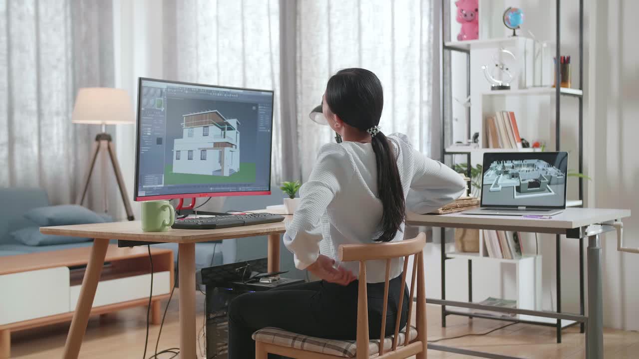 아시안 여성 엔지니어가 집에서 데스크에서 집을 설계하는 동안 허리 통증을 겪고 있습니다.