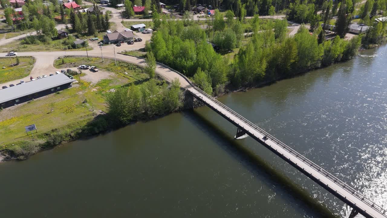 Dronekuvaa metsäkadosta Kanadan metsässä. Joki virtaa vuorten vieressä alkuperäiskansojen kylässä.