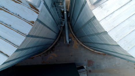 large metal hangar. grain elevators outdoors. aluminum containers for storing grain. agribusiness. modern industrial plant. motion down.