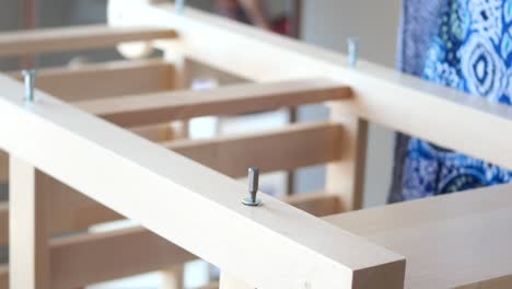 person assembling furniture with a screwdriver