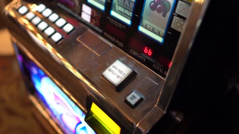 pov closeup hand hits button to start gambling on slot machine in casino