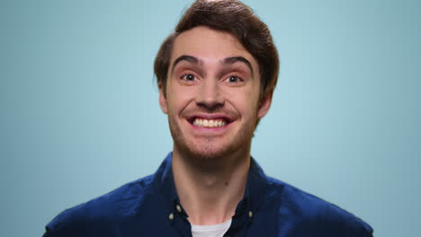 Surprised-man-posing-on-blue-background.-Excited-guy-looking-at-camera