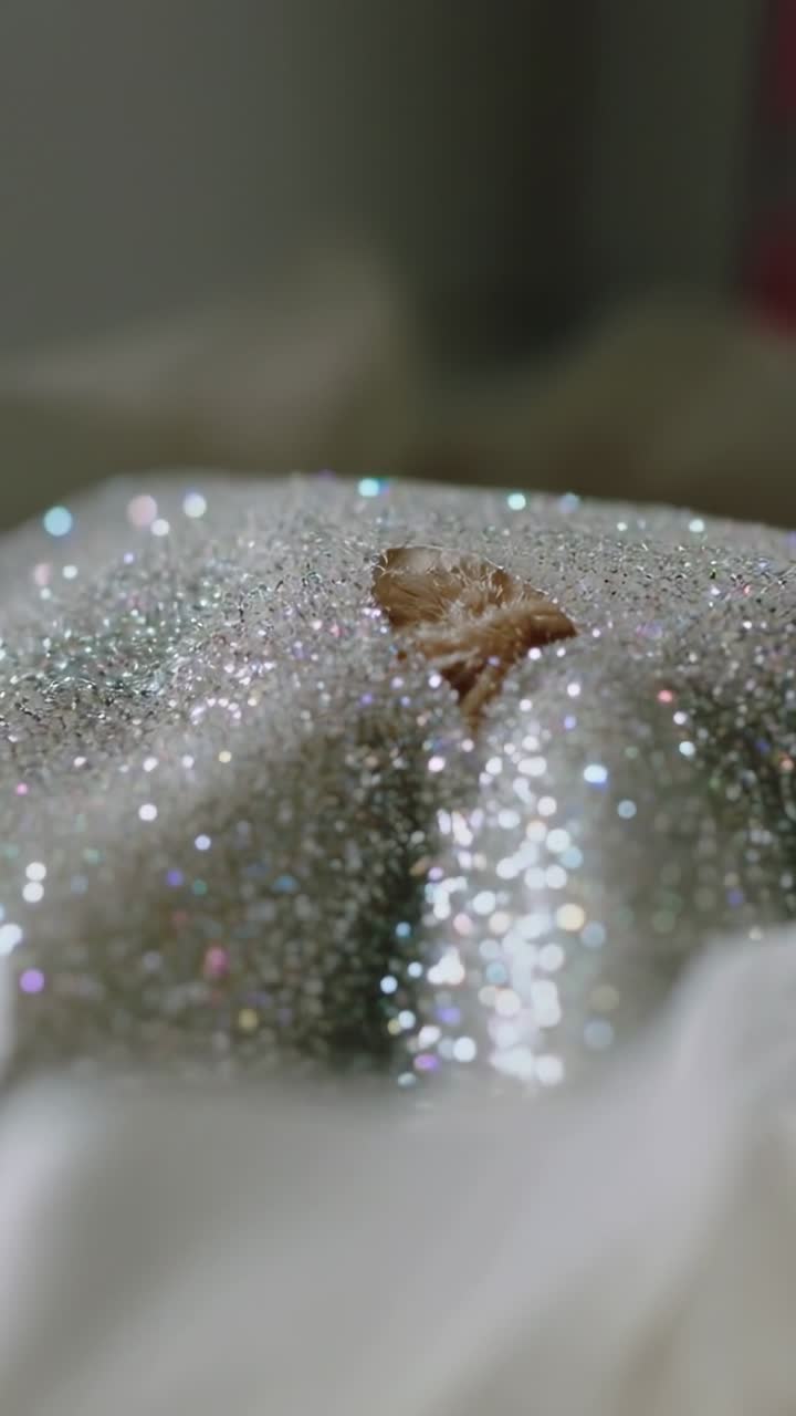 Video verticale: la fotocamera rivela una zucca glitterata tra la carta velina in una scatola floreale sulla scrivania che mostra glitter