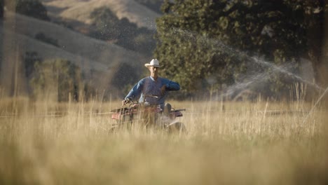 Peón-Del-Rancho-Recorre-Los-Aspersores-De-Agua-En-Su-Vehículo-Todo-Terreno-En-Cámara-Lenta