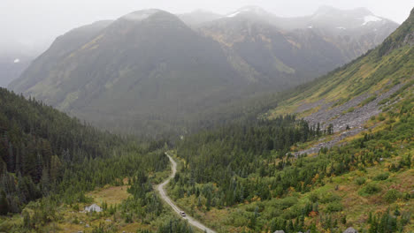 aerial static view of vehicle driving dirt road in british columbia mountains