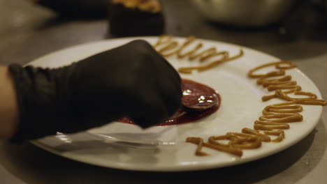 Mire-Cómo-Un-Hábil-Chef-Rocía-Cuidadosamente-La-Sabrosa-Salsa-En-Un-Plato-Bellamente-Presentado,-Agregando-El-Toque-Final-De-Sabor-Y-Elegancia-Al-Plato