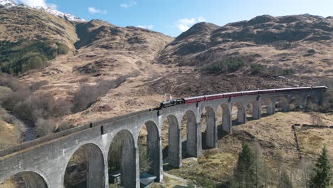 la toma del avión no tripulado revela el famoso viaducto de glenfinnan con el tren de la máquina de vapor jacobite