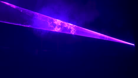 robotic purple laser lights reflecting off the smoke of a dance floor