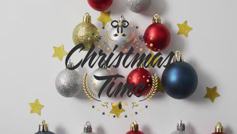 Animation-of-christmas-time-text-over-christmas-decorations