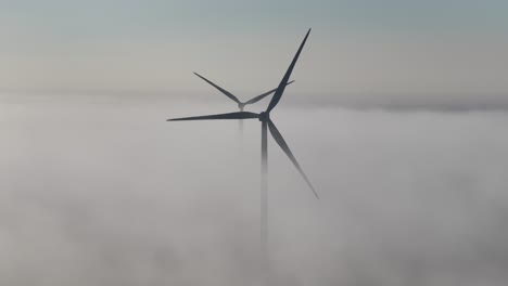 aerial above the fog on a wind farm at dawn