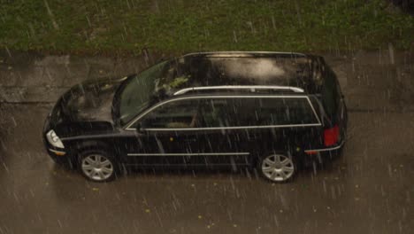 Fuerte-Lluvia-Golpea-Un-Auto-Estacionado-En-El-Patio-De-Un-Edificio-De-Apartamentos