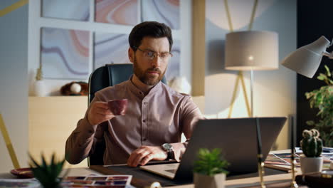 entrepreneur looking laptop screen working office close up. man drinking coffee.