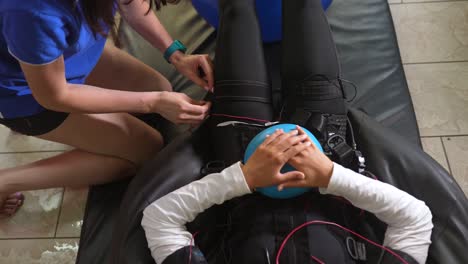 sesión de fisioterapia con equipo de estimulación muscular