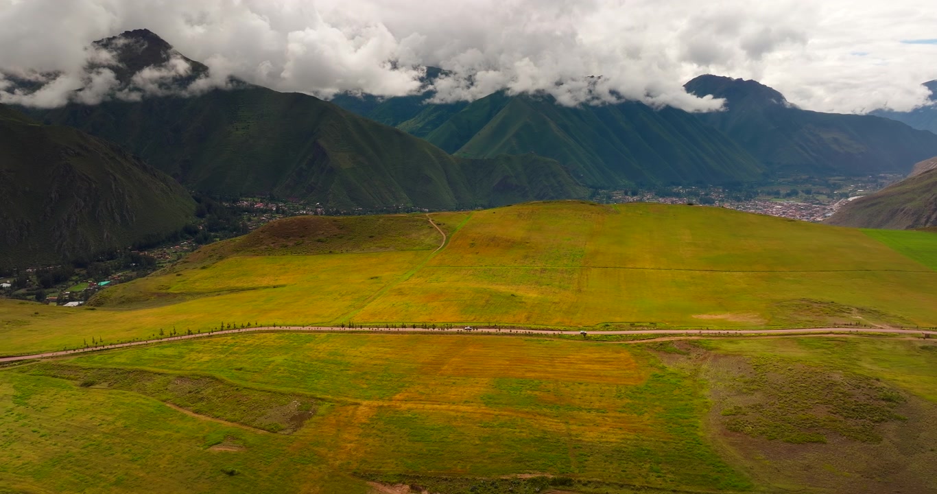 Vista aerea di campi agricoli, una strada sterrata e montagne nel distretto di Maras, Valle Sacra, Perù