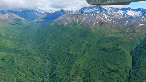 Flying-along-a-remote-mountain-valley-in-the-Talkeetna-Range-of-Alaska,-filmed-from-a-small-airplane-with-an-action-camera