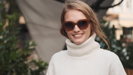 Caucasian-female-wearing-sunglasses-and-sweater-outdoors.