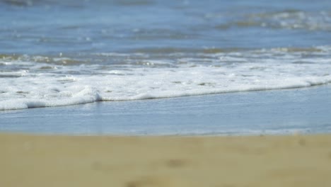 waves of mediterranean sea rolling in sunshine to the sandy beach