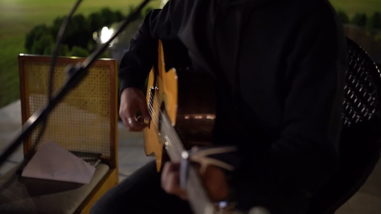 A man playing on a guitar in the theatre, close up shot, insert shot
