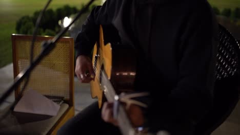 a man playing on a guitar in the theatre, close up shot, insert shot