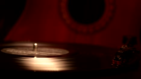 slider shot. disco de vinilo vintage tocando en el reproductor y la guitarra acústica en el fondo con humo de naranja de fuego. concepto de crimen o blues con instalación de automóvil de juguete. enfoque selectivo