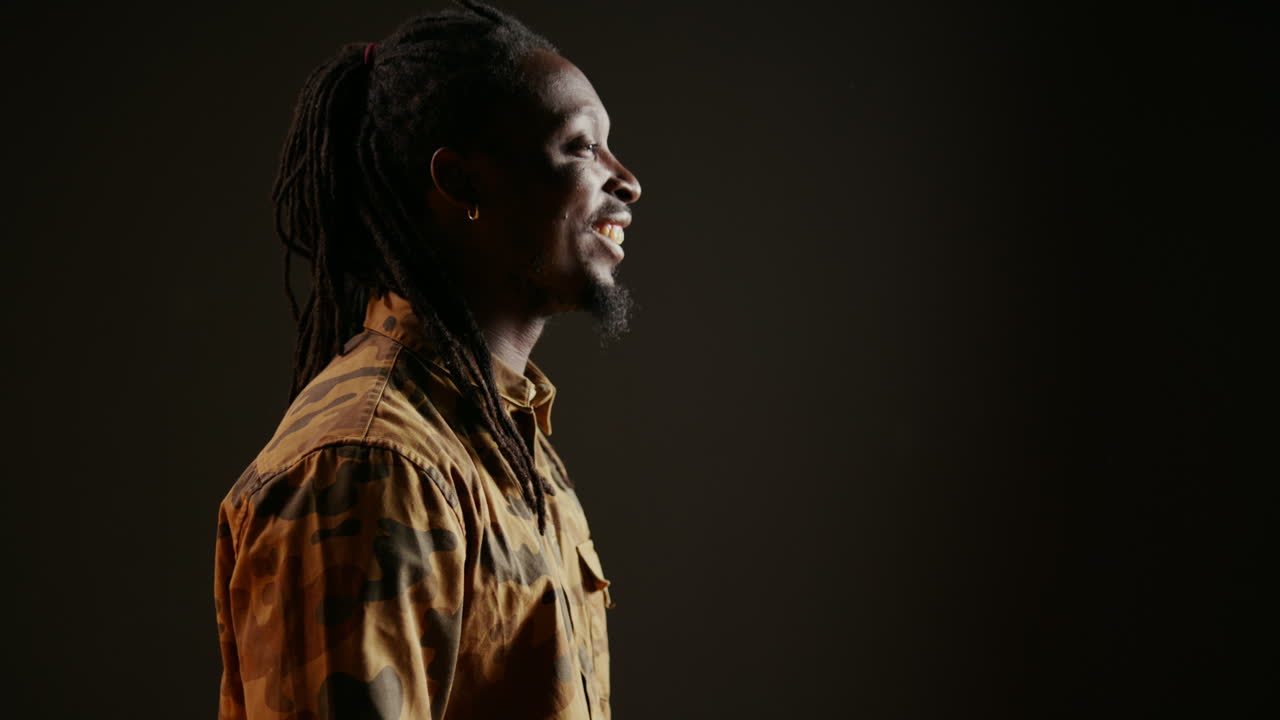 Uomo afroamericano che si diverte in uno studio nero.