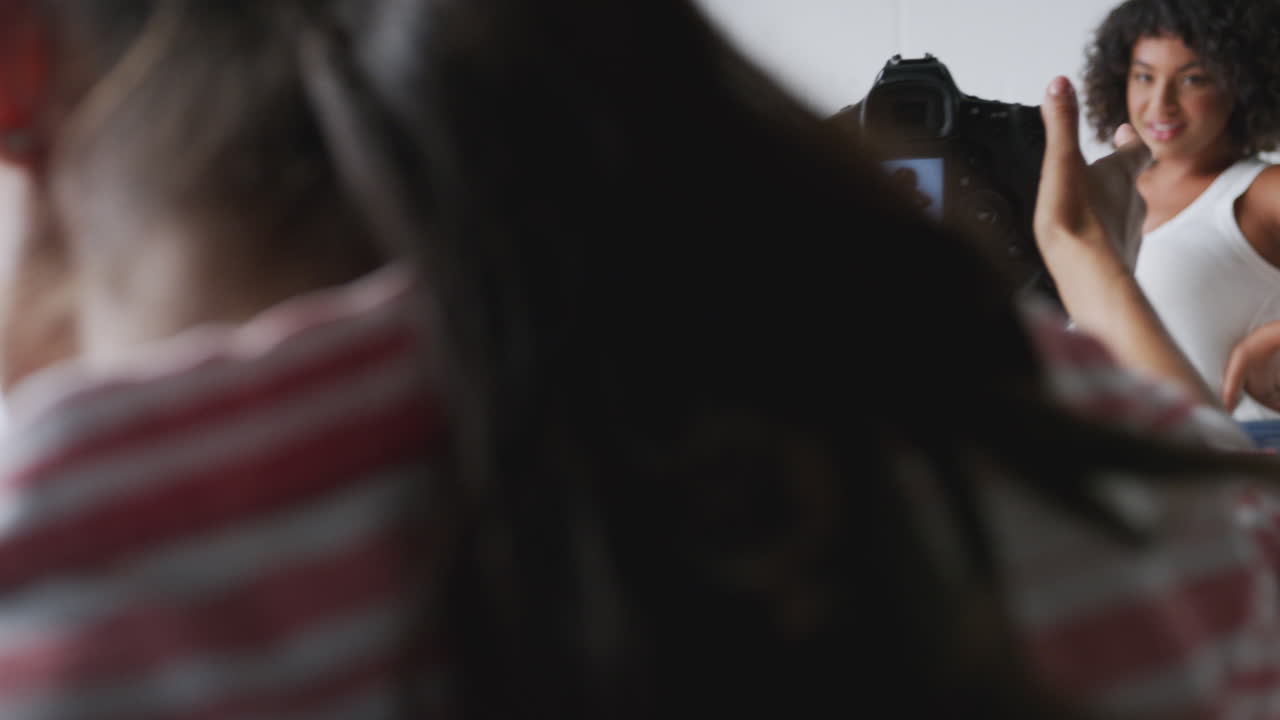 fotógrafa en un estudio digital disparando imágenes en una cámara atada a una computadora portátil