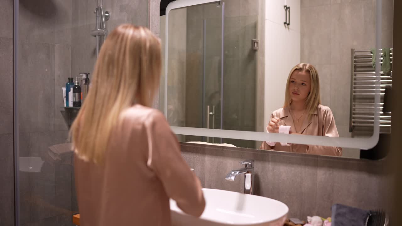 Donna che si lava il viso in bagno