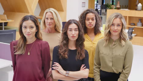 retrato de un equipo empresarial femenino multicultural de pie en una oficina moderna de plan abierto