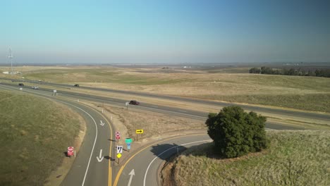 a static drone view of highway 5 near newman, featuring orderly farmland rows, gently curving roads, and serene rural vistas.