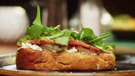 cooking prosciutto sandwich close-up. toast bread with ham, spinach and cottage cheese. tasty snack. bruschetta with meat and lettuce