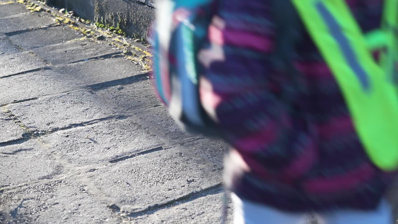 Children walking on a sidewalk casting long shadows