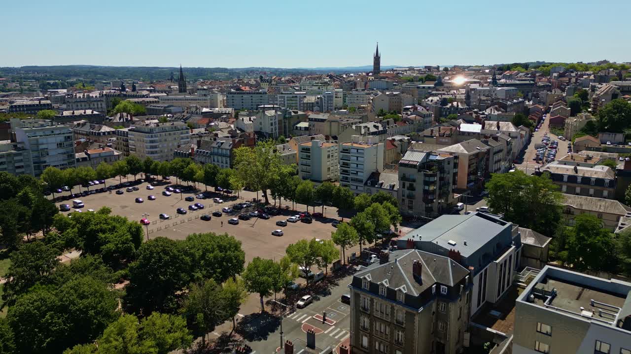 Forward drone fly over the Limoges cityscape with church spire and old buildings under summer sky, neighborhood station, Haute-Vienne, France