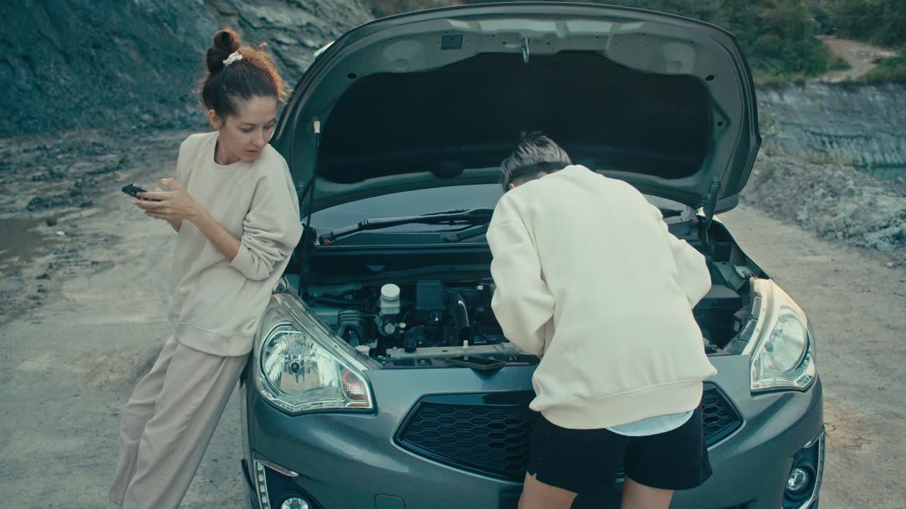 Two women dealing with a broken down car