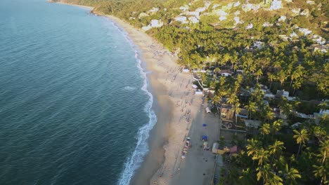 La-Playa-De-Sayulita,-México,-Tiene-Gente-Bronceándose-Y-Caminando-Por-La-Orilla-Vista-Desde-El-Punto-De-Vista-De-Los-Drones